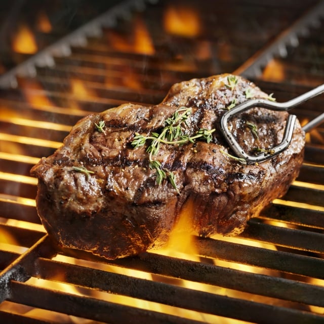 Close up view of a Sirloin steak being grilled on the bbq