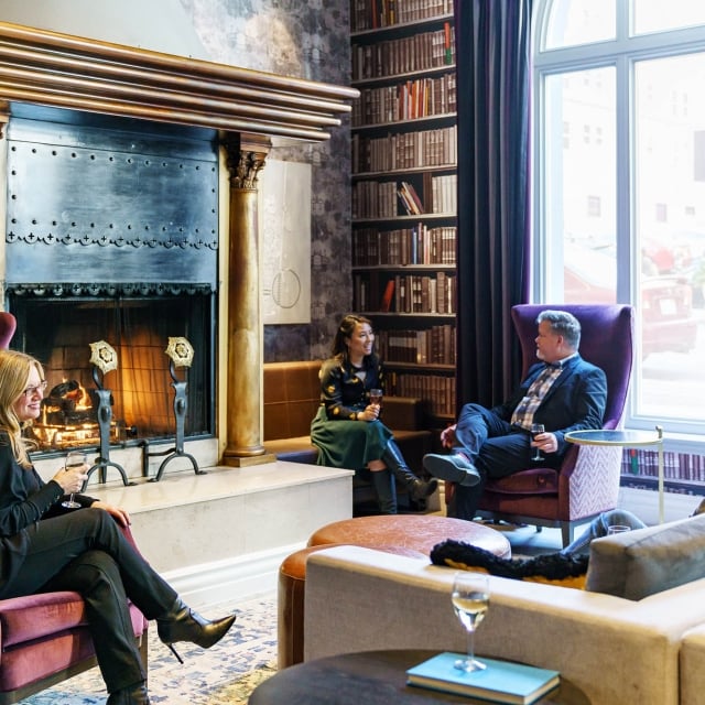 A group of people enjoying a conversation in The Living Room during social hour at The Marker